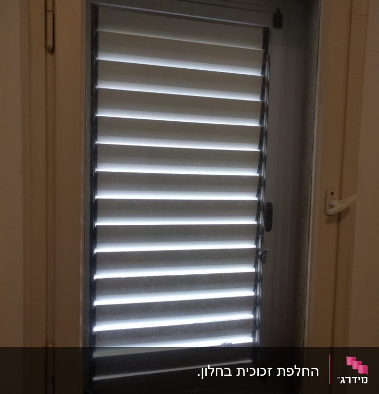 חלון זכוכית עם תריסים סגורים למחצה